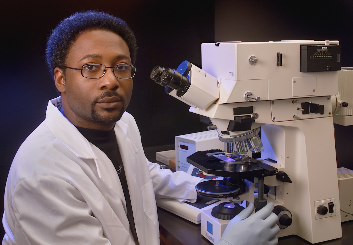 Scientist reviewing material samples with analytical equipment